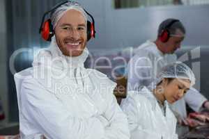 Smiling butcher in protective headphones
