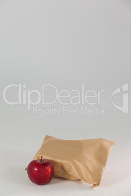 Brown paper lunch bag with red apple