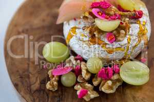 Brie cheese, grapes and nuts on wooden board