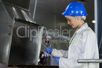 Technician examining meat processing machine