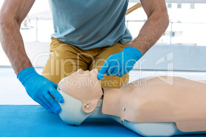 Mid section of paramedic practising resuscitation on dummy