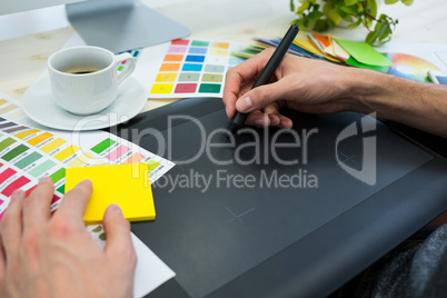 Graphic designer working on graphic tablet at his desk