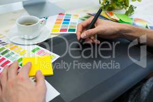 Graphic designer working on graphic tablet at his desk