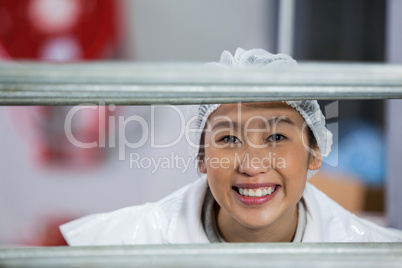 Female butcher standing in meat factory