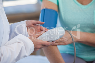 Female doctor checking blood pressure of a patient