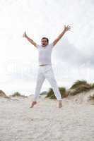 Excited man jumping on beach