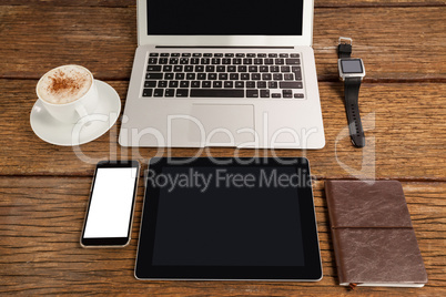 Laptop, smartwatch, smartphone and digital tablet with cup of coffee