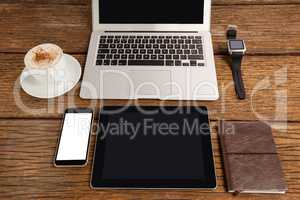 Laptop, smartwatch, smartphone and digital tablet with cup of coffee