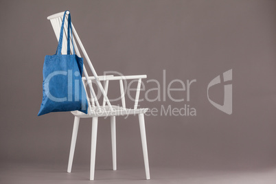 Blue bag hanging on a white chair