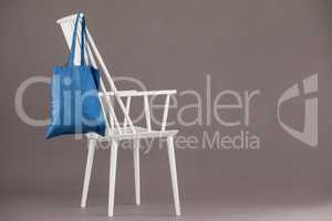 Blue bag hanging on a white chair