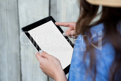 Woman in blue top using digital tablet
