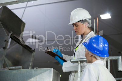Technicians examining meat processing machine