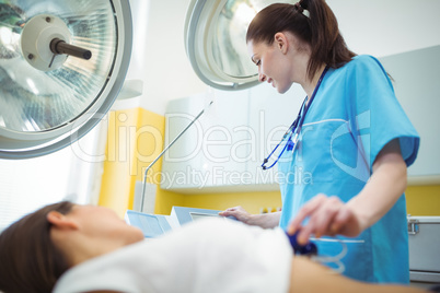 Nurse performing an electrocardiogram test on the patient