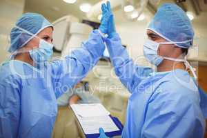 Male and female surgeon giving high-five to each other