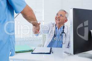 Doctor and surgeon shaking hands