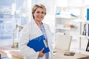 Portrait of a smiling female doctor holding clipboard