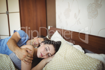 Romantic couple sleeping on bed