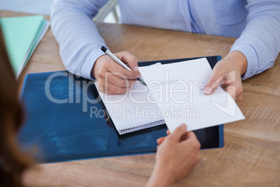 Doctor writing prescription for patient