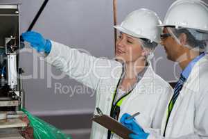 Technicians examining meat processing machine