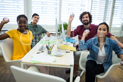 Team of business executives holding crumpled paper at desk