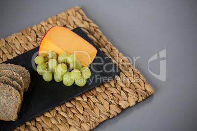 Gouda cheese and grapes on slate plate