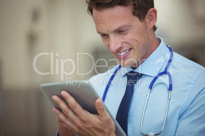 Male doctor using digital tablet in corridor