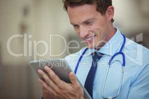 Male doctor using digital tablet in corridor