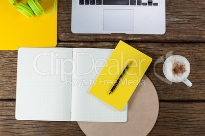 Laptop, diary, pen, coffee mug and headphones