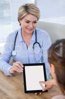 Doctor showing digital tablet to patient