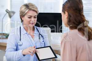 Doctor showing digital tablet to patient