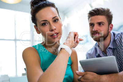 Man holding digital tablet while colleague looking at camera