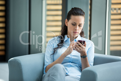Businesswoman sitting and using a mobile phone
