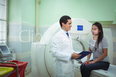 Doctor and patient discussing over clipboard