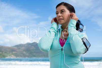 Thoughtful woman listening to music on headphones