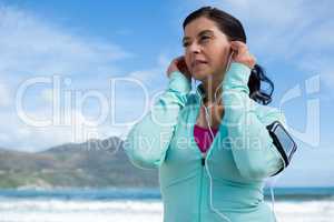 Thoughtful woman listening to music on headphones