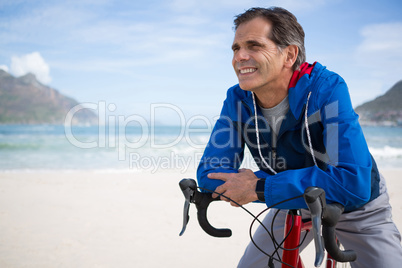 Smiling man leaning on bicycle