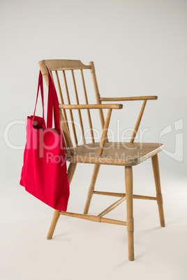 Red bag hanging on a wooden chair