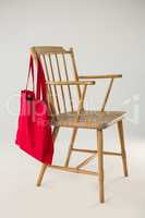 Red bag hanging on a wooden chair