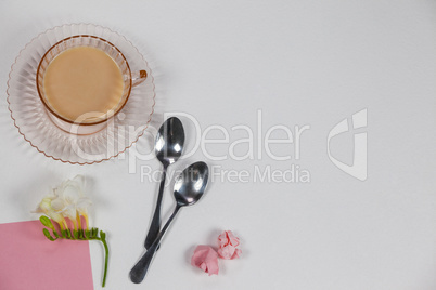 Cup of tea, spoons, blank page, paper balls and flower