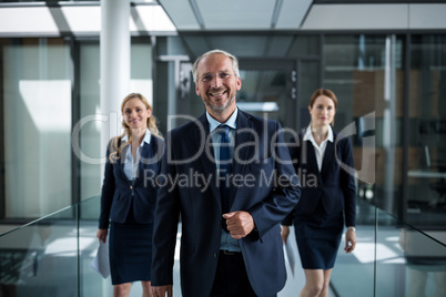 Business colleagues walking together in office corridor