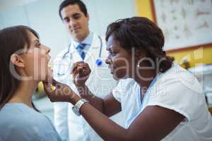 Nurse examining female patients mouth