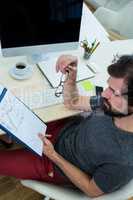 Business executive looking at clipboard at his desk