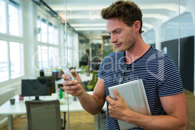 Male business executive using on mobile phone in office