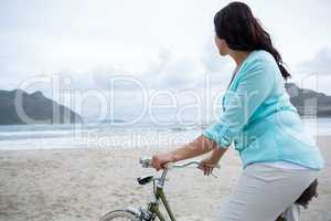 Woman standing with bicycle on beach