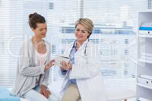 Doctor discussing with patient over digital tablet