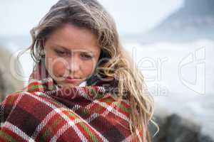 Thoughtful woman wrapped in shawl