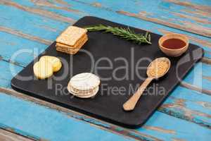 Rosemary, cheese and biscuits with spices on slate board