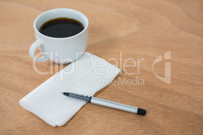 Black coffee with tissue paper and pen