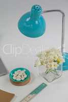 Table lamp, flowers, pebbles and ruler
