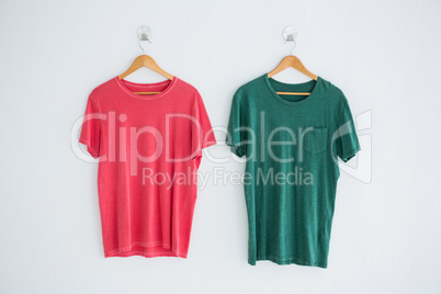 Pink and green t-shirts hanging on hanger